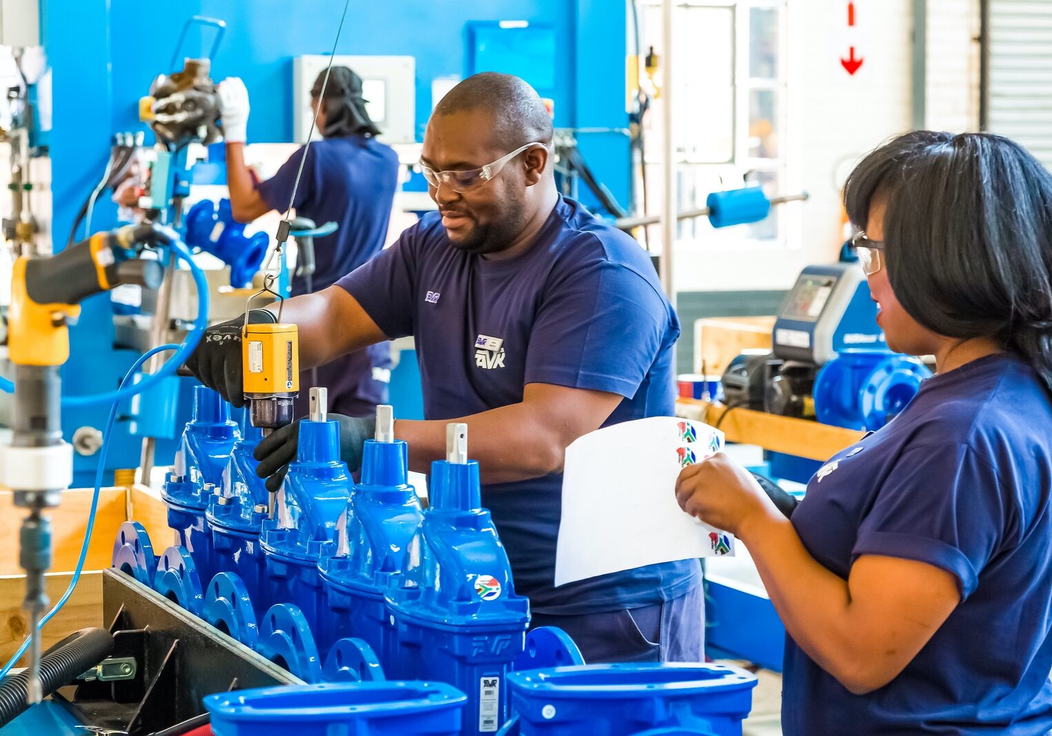 A man and woman working on blue bottles.